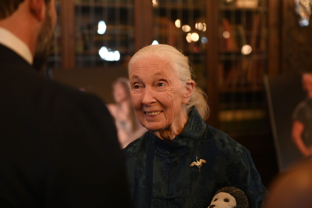 Jane Goodall smiling while talking to someone at the event.