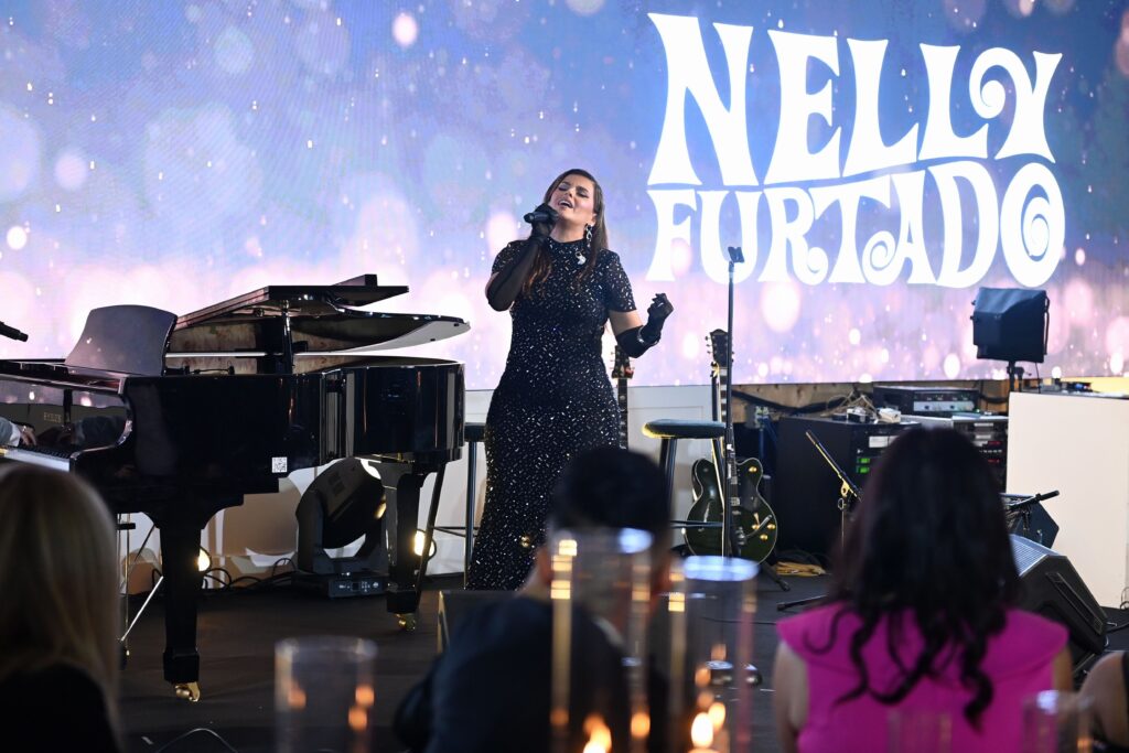 Nelly Furtado on stage singing into a microphone.