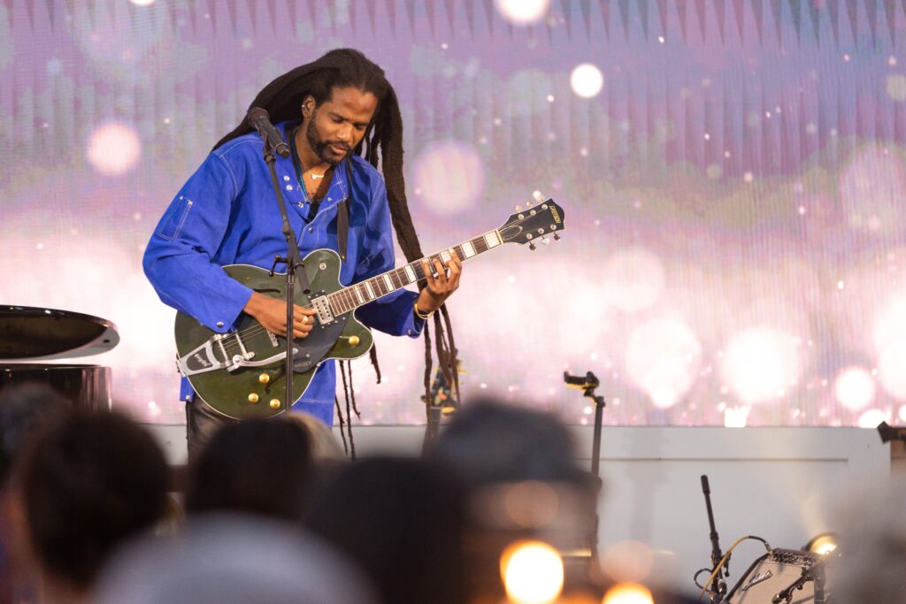 Paul Beaubrun performing on stage with a guitar in hand.