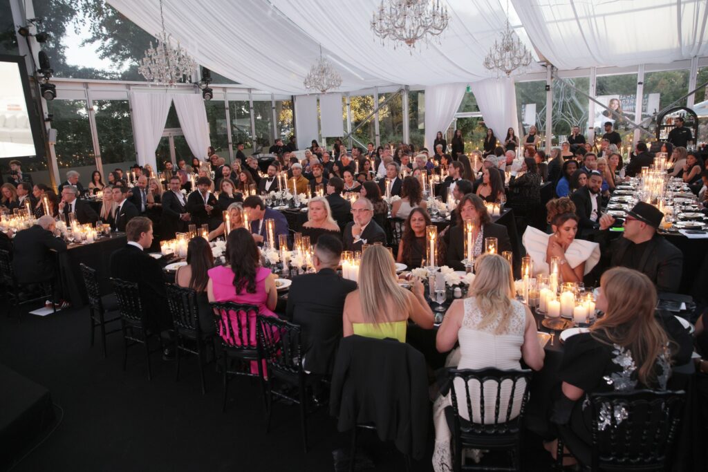 People sitting at tables for the gala watching a performance.