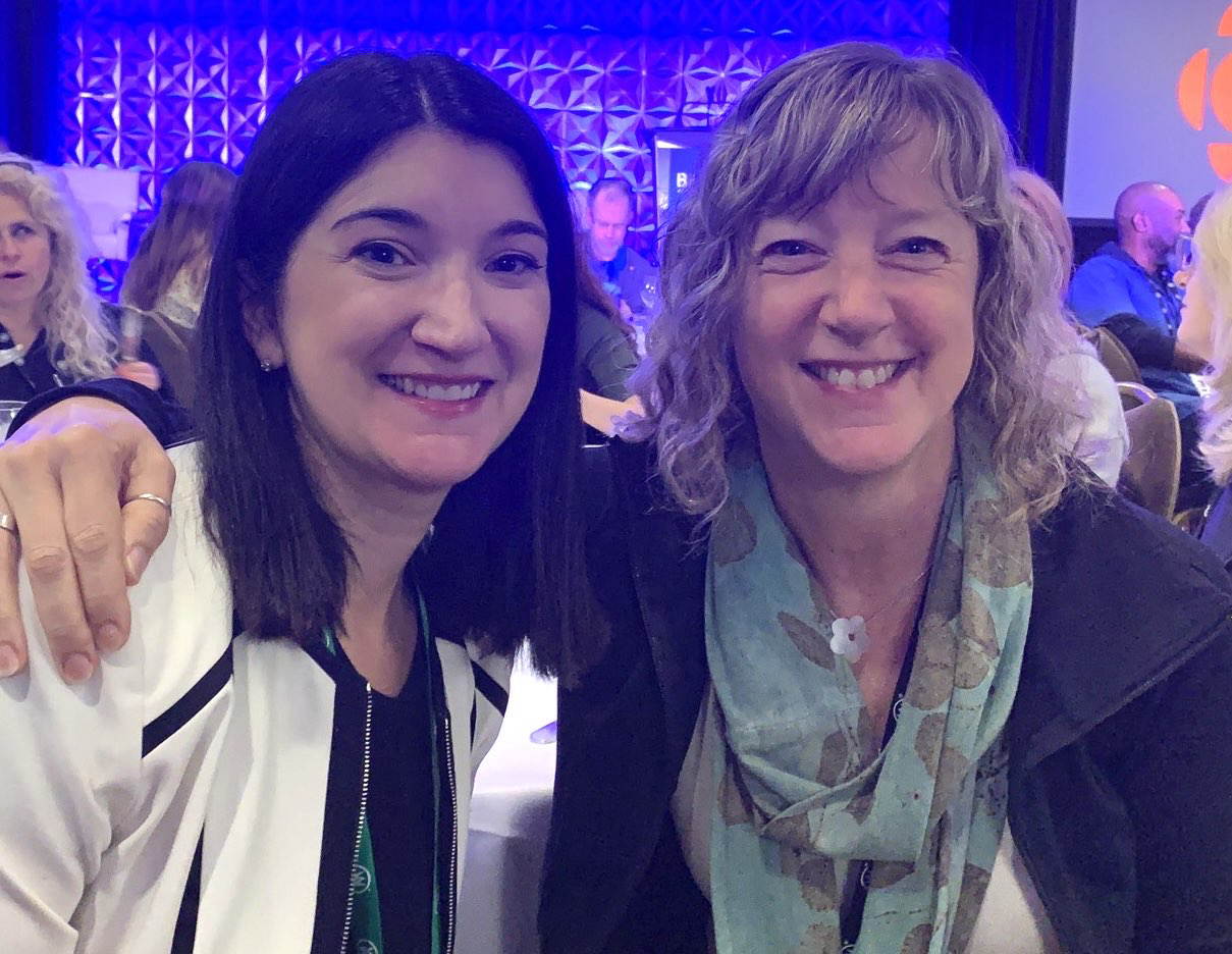 Two women smiling at the camera.