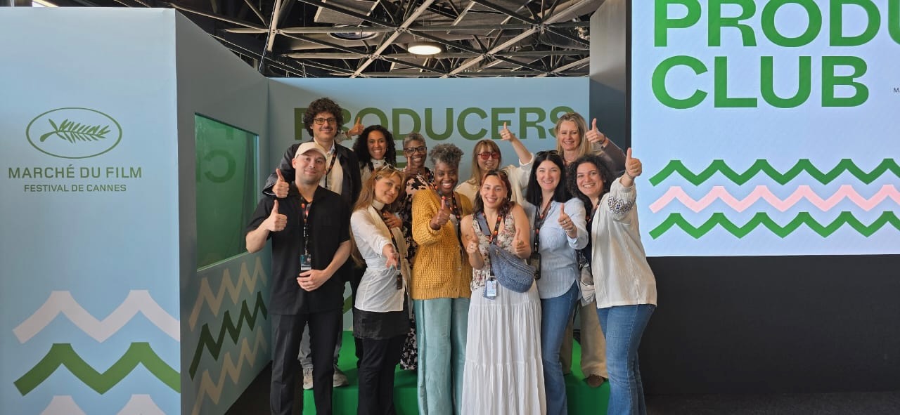 Cannes impACT Lab for Producers 2025 Group of 11 people smiling with their thumbs up next to a sign that says Producers Club and Marché du Film Festival De Cannes